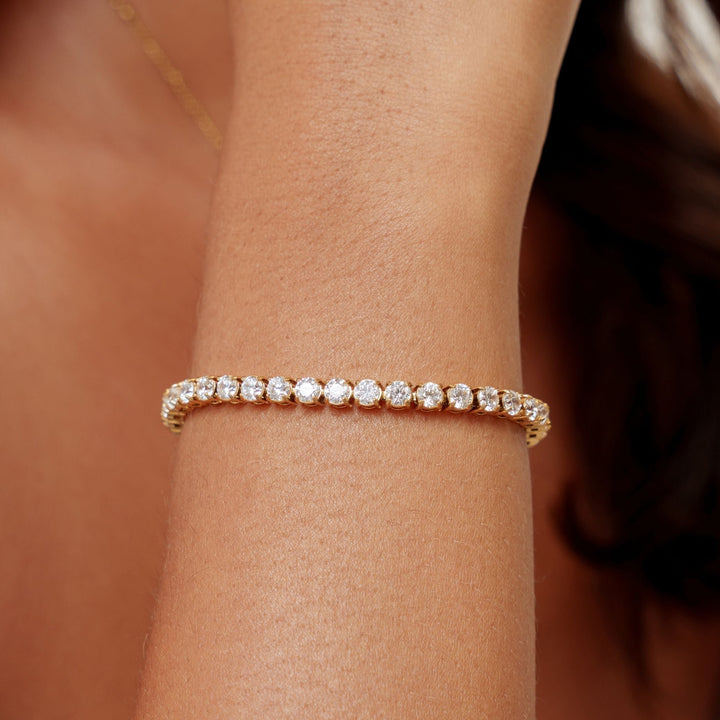 Detailaufnahme: Goldenes Damen Tennisarmband mit funkelnden Zirkonsteinen. Wasserdicht & verstellbar.