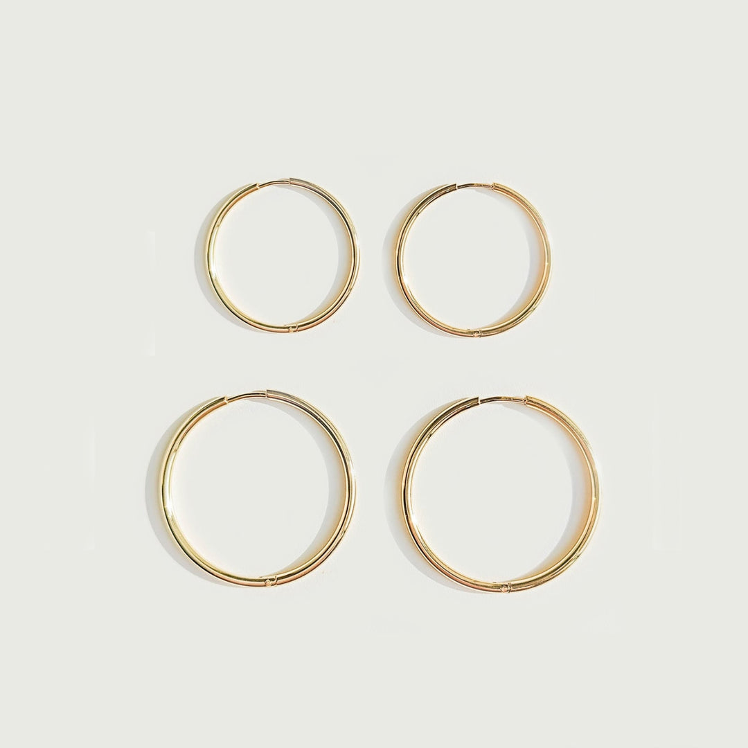 Detailaufnahme: glänzende dünne Damen Creolen aus wasserfestem Gold- oder Silber-Edelstahl, hypoallergen.