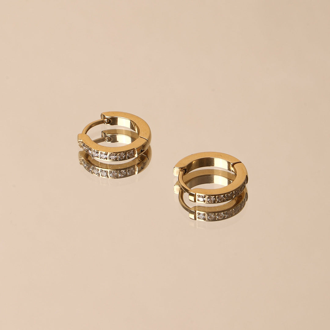 Damenohrringe: Goldene Mini Creolen mit Zirkonia am Ohr getragen. Eleganter, wasserfester & hypoallergener Ohrschmuck.
