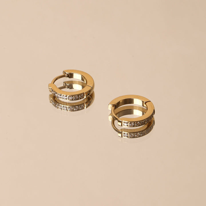 Damenohrringe: Goldene Mini Creolen mit Zirkonia am Ohr getragen. Eleganter, wasserfester & hypoallergener Ohrschmuck.