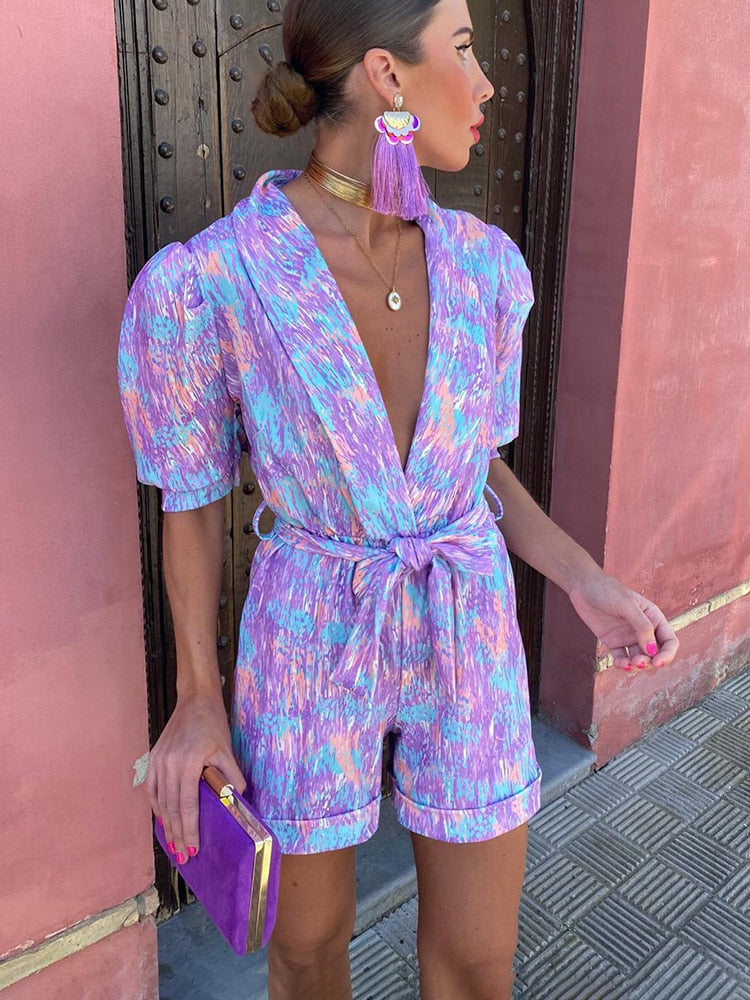 Trendiger Damen Print-Playsuit mit femininen Puffärmeln, V-Ausschnitt und Gürtel. Kurz & elegant für den Sommer.