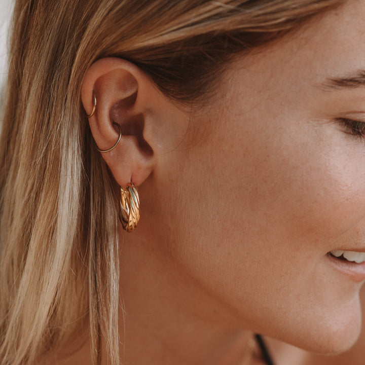 Hochwertige, wasserdichte Goldohrringe für Damen. Gedrehtes Creolen-Design aus hypoallergenem Edelstahl.