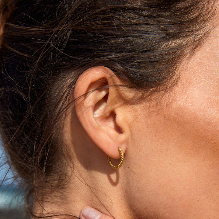 Goldene, gedrehte Edelstahl-Creolen für Damen, elegant & alltagstauglich.
