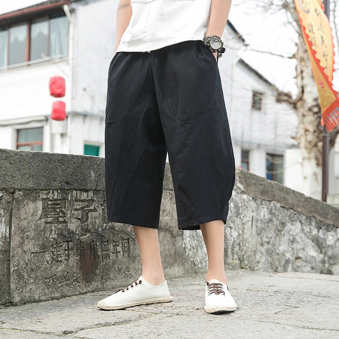 Mann trägt stylische Dreiviertelhose am Strand. Moderne Herren Sommerhose, bequem und ideal für Freizeit.