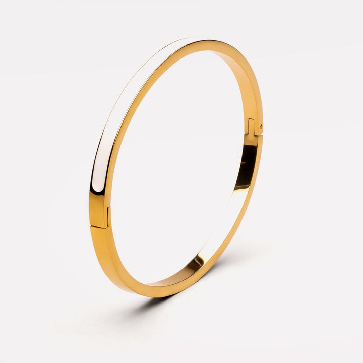 Detailaufnahme: Glänzender Gold-Weiß Armreif aus Edelstahl. Hypoallergene, wasserfeste Damenschmuck für jeden Tag.